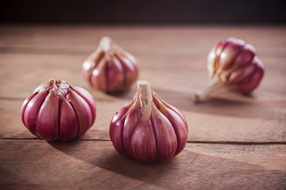 Cipolle rosse e spicchi di aglio su tagliere di legno